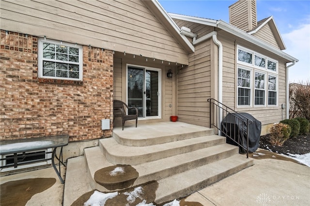 view of exterior entry featuring a patio area