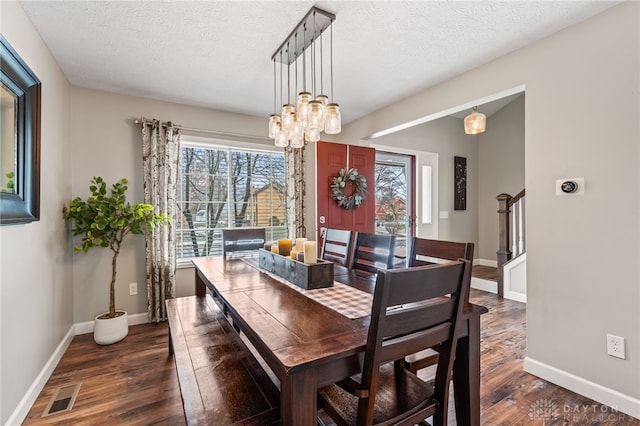 dining space featuring a wealth of natural light, dark wood-type flooring, and a textured ceiling