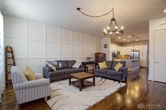 living room with dark hardwood / wood-style floors and a chandelier