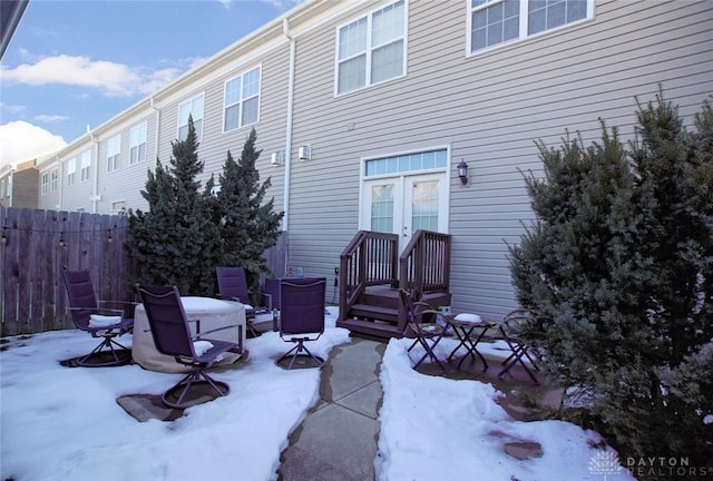 view of snow covered back of property