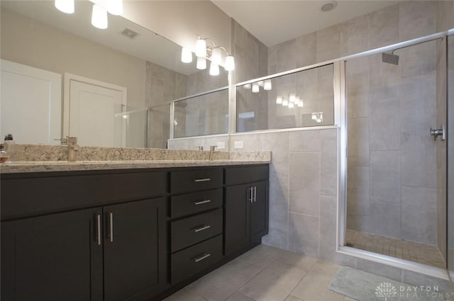 bathroom featuring tile patterned flooring, vanity, and a shower with shower door