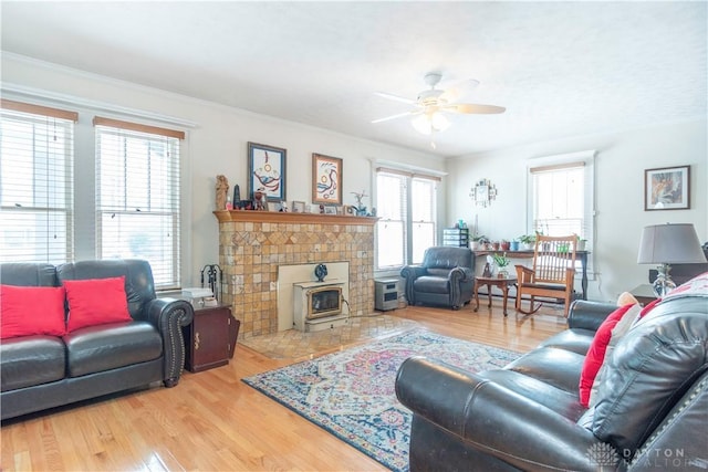 111 W Pinehurst St, Sidney, OH 45365 - living area featuring wood finished floors, a healthy amount of sunlight, a ceiling fan, and a wood stove