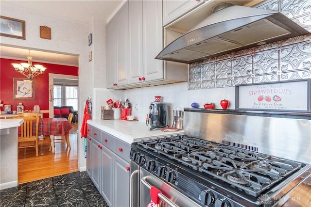 111 W Pinehurst St, Sidney, OH 45365 - kitchen with range hood, stainless steel range with gas stovetop, a chandelier, decorative backsplash, and pendant lighting