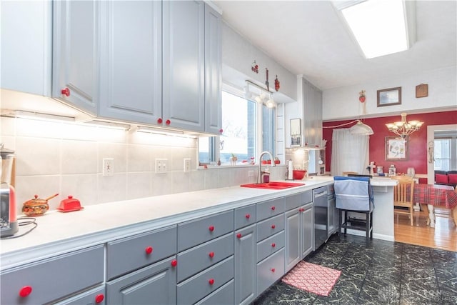 111 W Pinehurst St, Sidney, OH 45365 - kitchen featuring tasteful backsplash, an inviting chandelier, stainless steel dishwasher, light countertops, and a sink