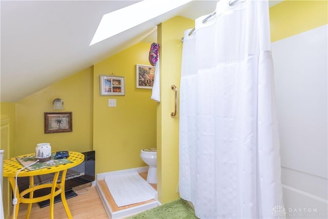 111 W Pinehurst St, Sidney, OH 45365 - full bath with vaulted ceiling with skylight, curtained shower, toilet, baseboards, and wood finished floors