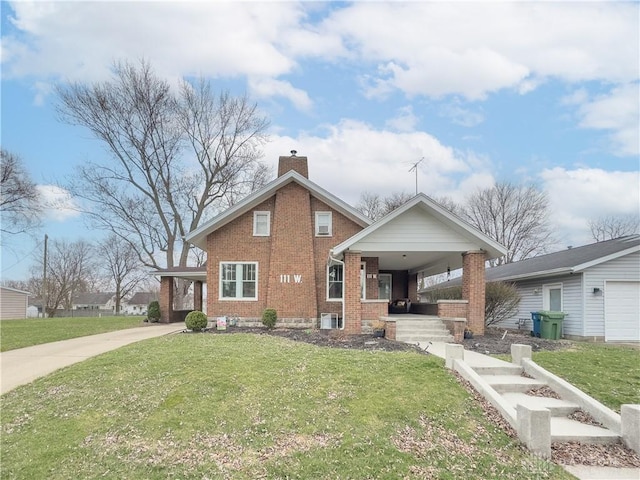 111 W Pinehurst St, Sidney, OH 45365 - view of front of house with a porch, a front yard, brick siding, a chimney, and concrete driveway