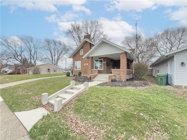 111 W Pinehurst St, Sidney, OH 45365 - bungalow featuring a front yard, a chimney, covered porch, and brick siding