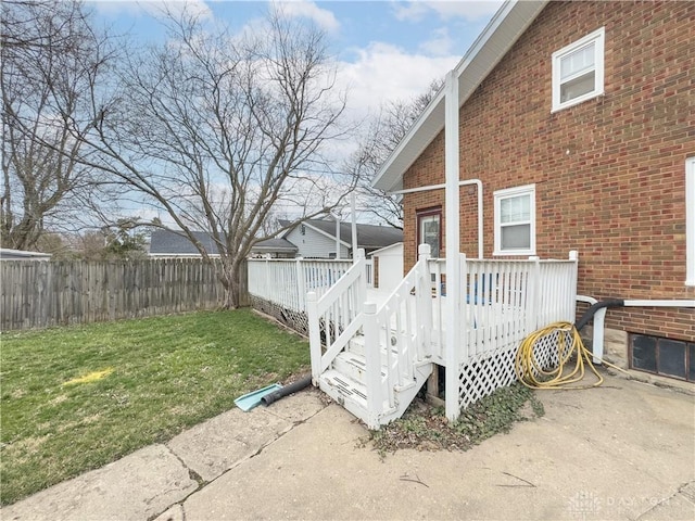 111 W Pinehurst St, Sidney, OH 45365 - exterior space with fence, a yard, a wooden deck, and brick siding