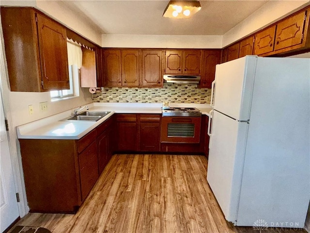 kitchen with sink, tasteful backsplash, white fridge, oven, and light hardwood / wood-style floors