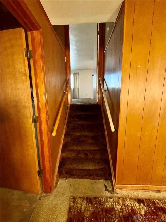 stairs featuring wood walls