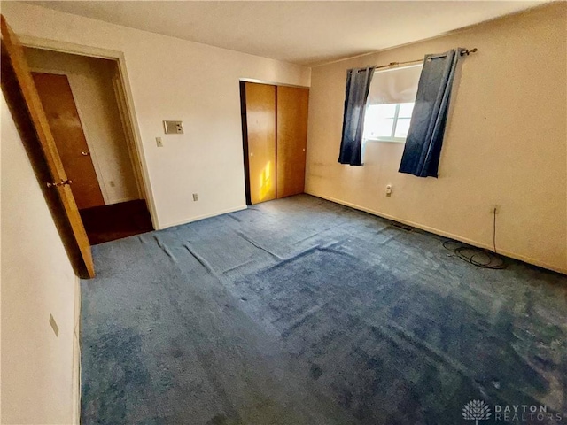 unfurnished bedroom featuring carpet flooring and a closet