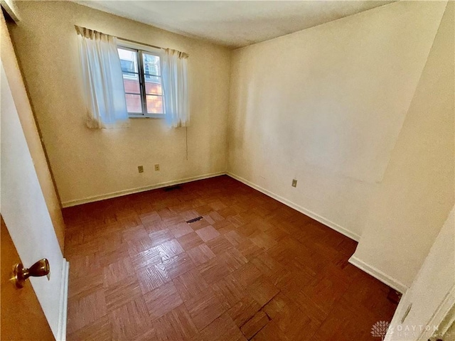 spare room featuring dark parquet floors