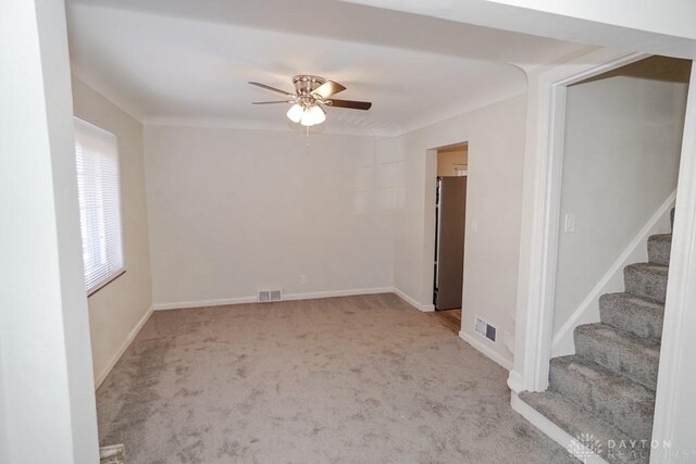 carpeted spare room with ceiling fan