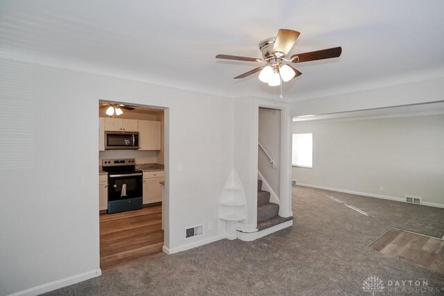 interior space featuring dark colored carpet and ceiling fan