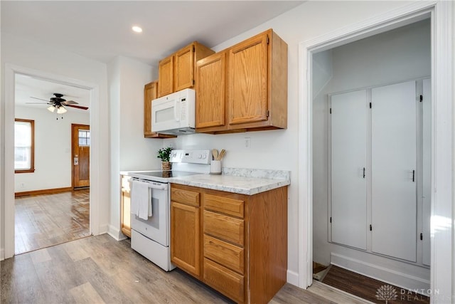 kitchen featuring ceiling fan, white appliances, and light wood-type flooring