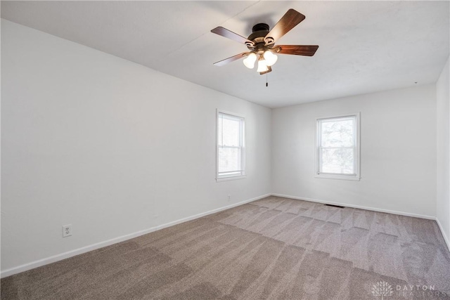 carpeted spare room featuring ceiling fan