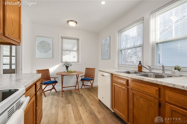 kitchen with sink, a wealth of natural light, white appliances, and light hardwood / wood-style flooring