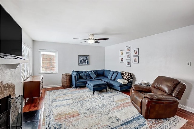 living room featuring dark wood-type flooring and ceiling fan