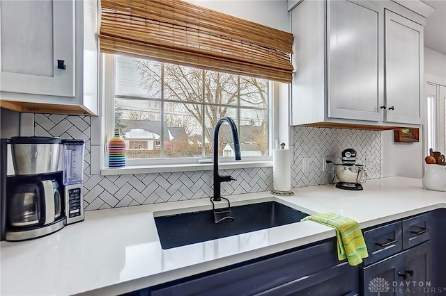 kitchen featuring white cabinets, sink, and backsplash