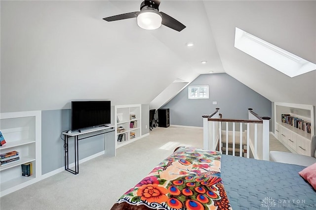 bedroom with lofted ceiling with skylight, light colored carpet, and ceiling fan