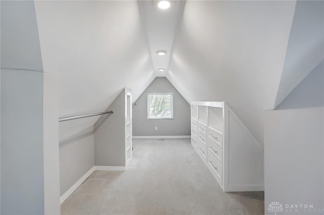 spacious closet featuring vaulted ceiling and light colored carpet