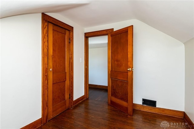 additional living space featuring lofted ceiling and dark hardwood / wood-style floors