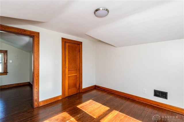 bonus room with dark wood-type flooring and lofted ceiling