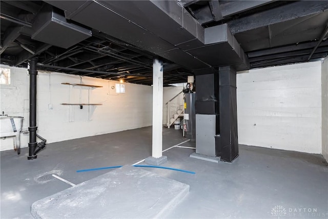 basement featuring heating unit, sink, and water heater