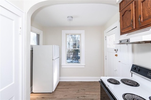 kitchen featuring white refrigerator, hardwood / wood-style floors, and electric range