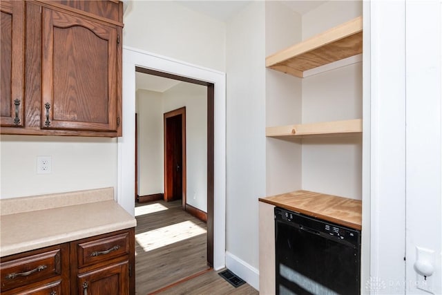 kitchen with dark hardwood / wood-style floors and black dishwasher