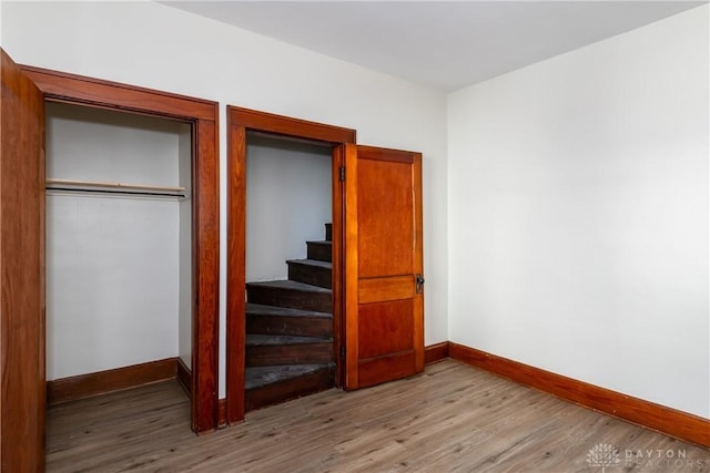 unfurnished bedroom with light wood-type flooring and a closet