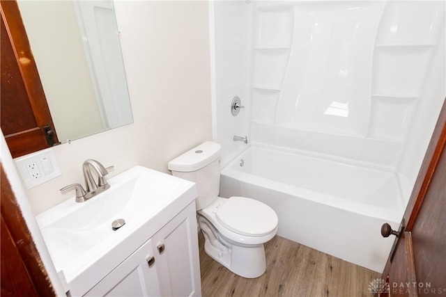 full bathroom featuring wood-type flooring, shower / washtub combination, vanity, and toilet