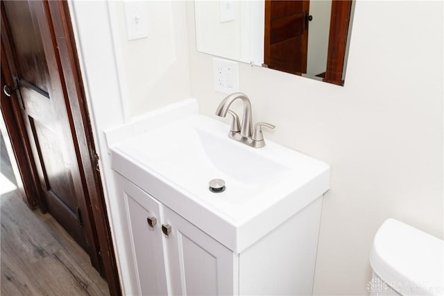 bathroom featuring hardwood / wood-style flooring, vanity, and toilet