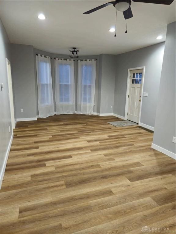 empty room with light hardwood / wood-style flooring and ceiling fan