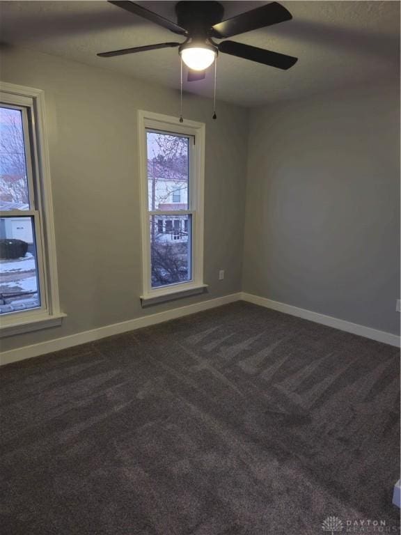 spare room featuring ceiling fan and carpet