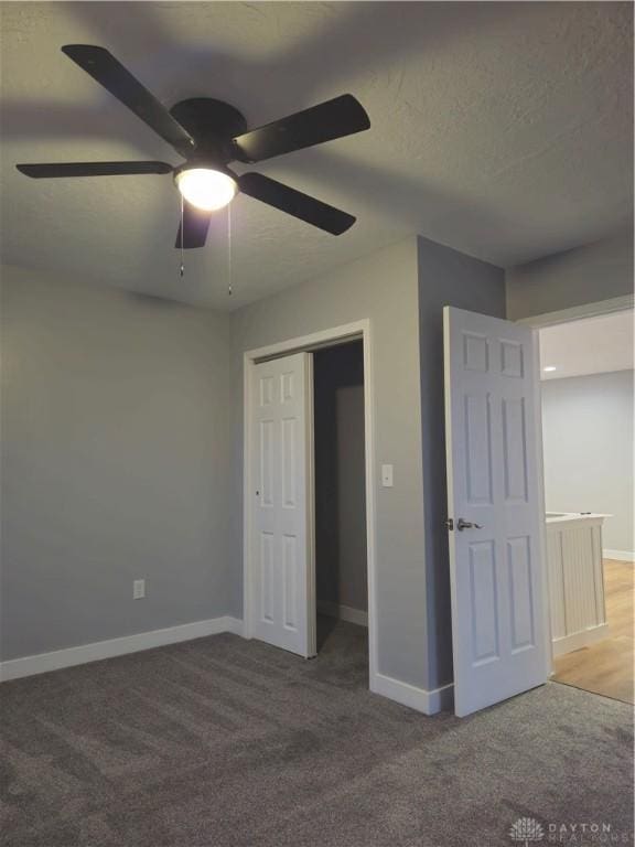 unfurnished bedroom featuring ceiling fan, carpet flooring, a textured ceiling, and a closet