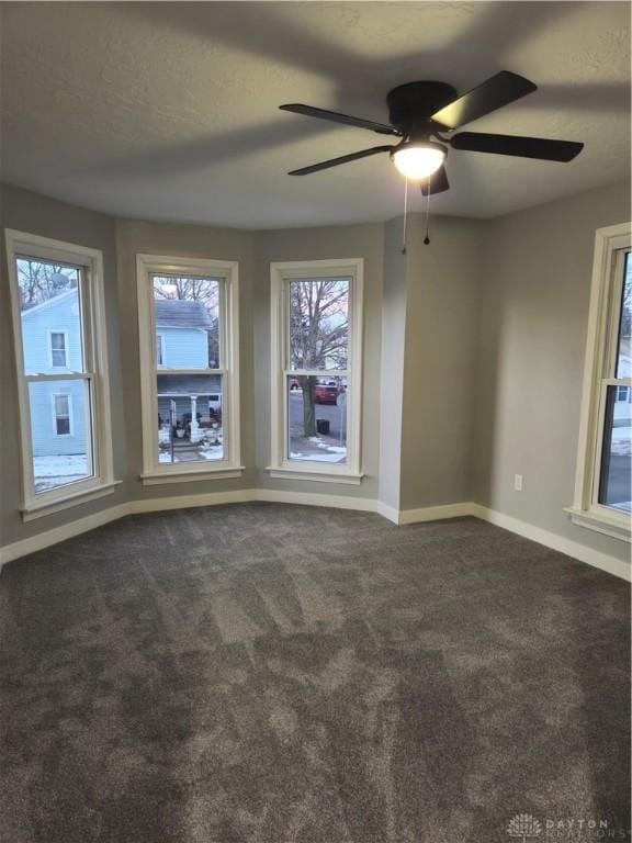 carpeted spare room with ceiling fan and a textured ceiling