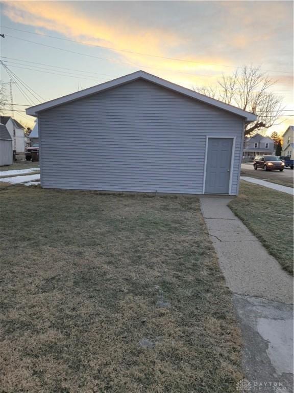 property exterior at dusk featuring a lawn