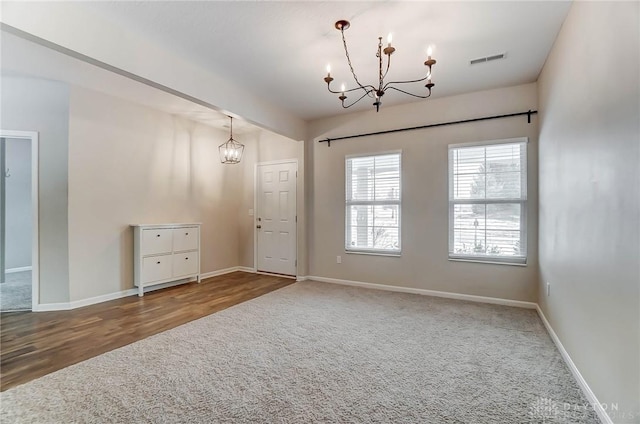 empty room with a chandelier and carpet floors