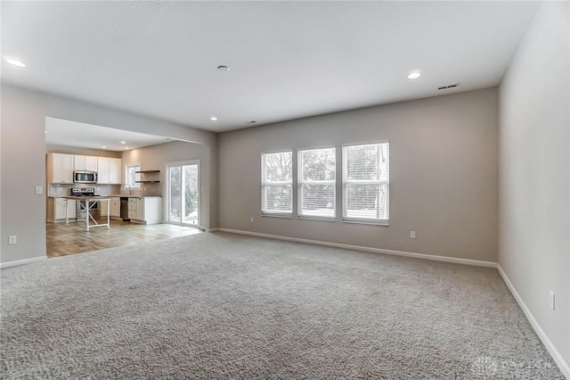 unfurnished living room with light colored carpet