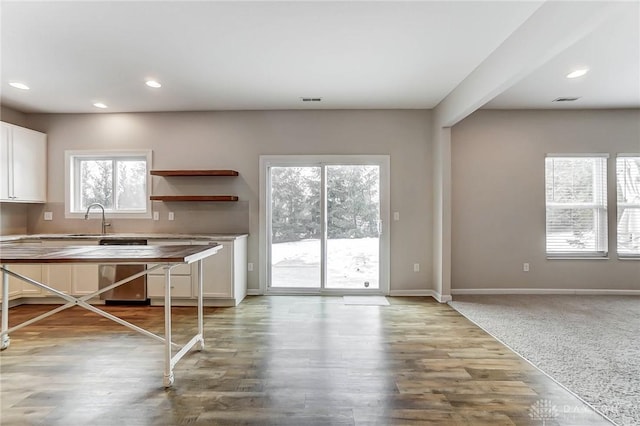 kitchen with white cabinetry, wood-type flooring, dishwasher, and sink