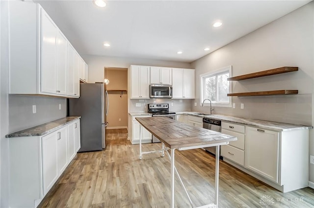 kitchen with tasteful backsplash, appliances with stainless steel finishes, sink, and white cabinets