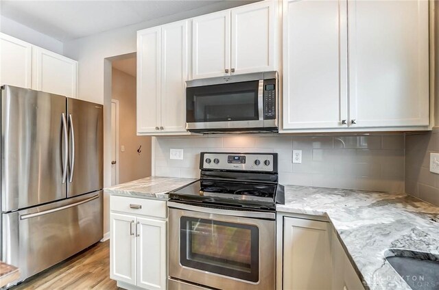 kitchen featuring light stone counters, appliances with stainless steel finishes, and white cabinets