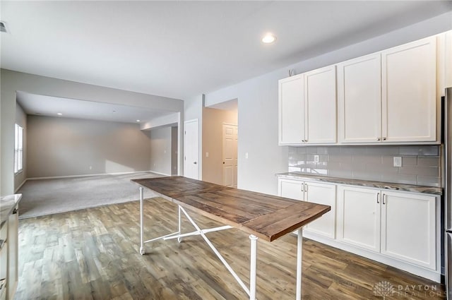 kitchen with white cabinetry, decorative backsplash, and dark wood-type flooring