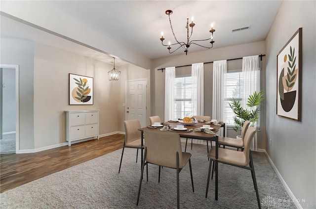 dining area featuring an inviting chandelier and dark hardwood / wood-style flooring