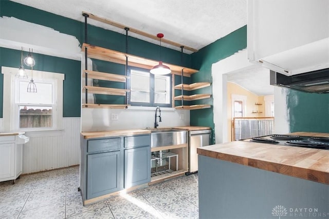 kitchen with wood counters, decorative light fixtures, sink, gray cabinetry, and stainless steel dishwasher