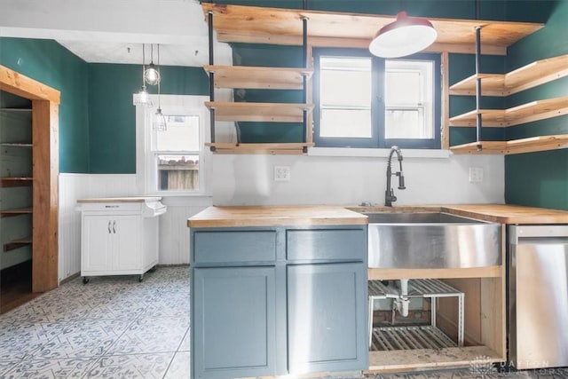 kitchen with wooden counters, decorative light fixtures, and a wealth of natural light