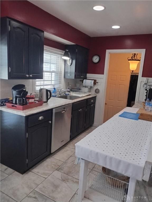 kitchen featuring sink, stainless steel dishwasher, and decorative light fixtures