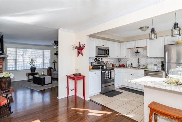 kitchen with hanging light fixtures, white cabinetry, and appliances with stainless steel finishes