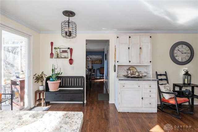 interior space featuring hanging light fixtures, ornamental molding, white cabinets, and dark hardwood / wood-style flooring